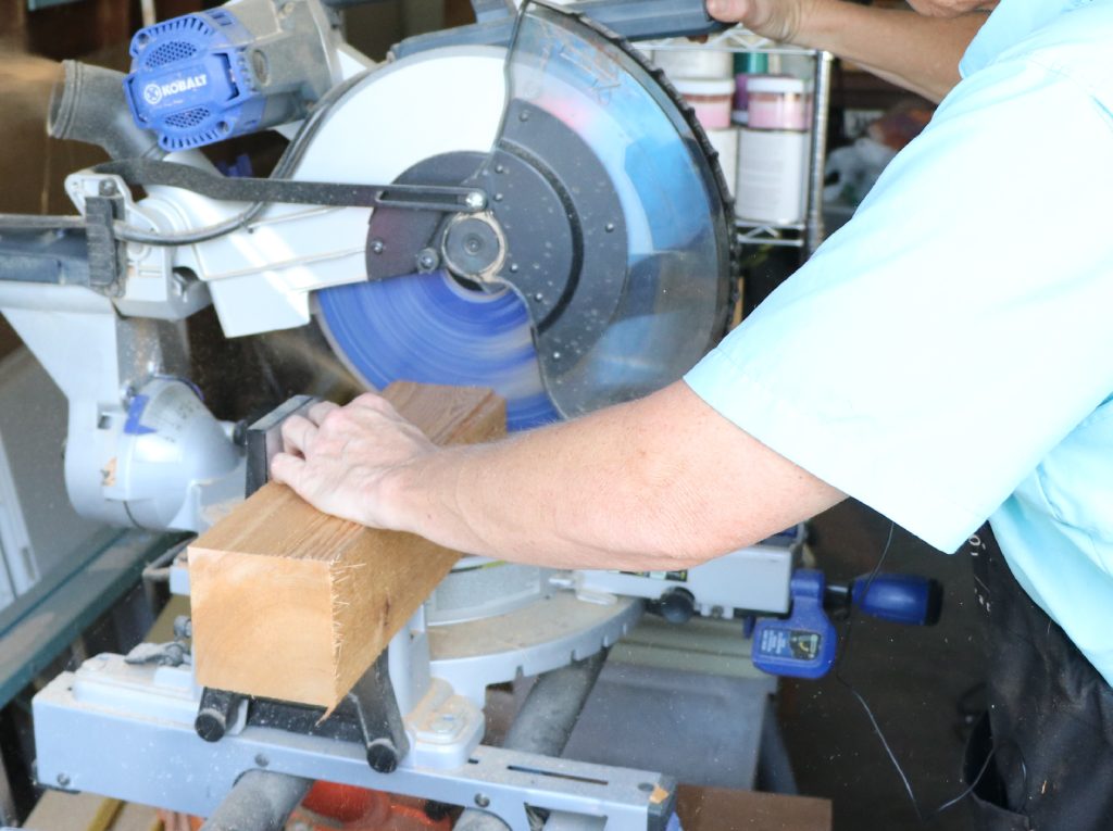 Step One: Cut Your Candle Sticks  Cut your 4 x 4 blocks, so they are flat on both ends. How short or long you cut them is up to you, but we recommend having at least three grouped together in varying lengths.