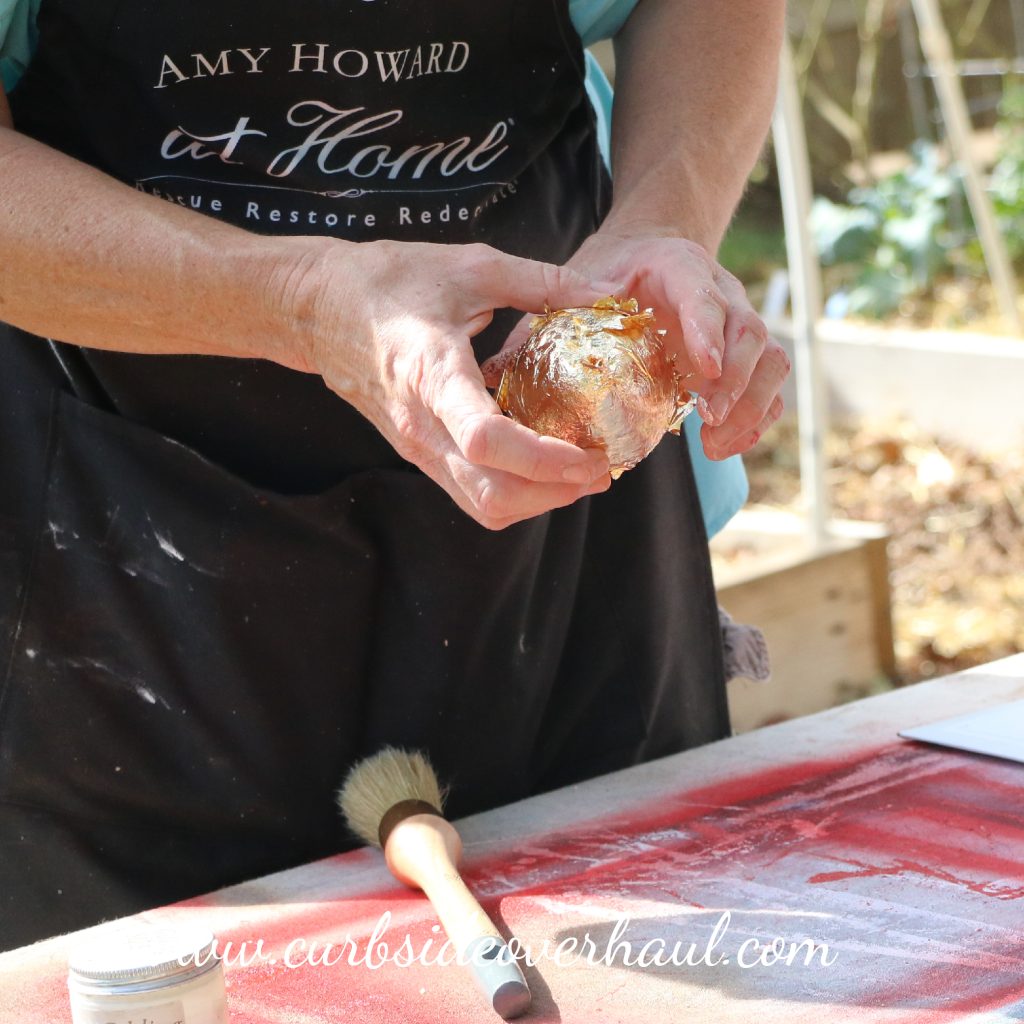Apply imitation gold leaf to paper mache pear
