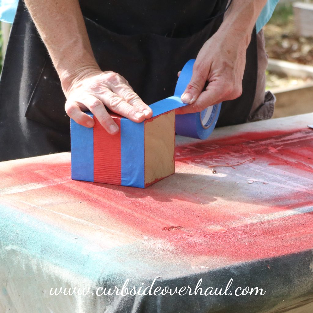 Step Three: Tape Off Your Blocks  Tape off the different sections of your block. The taped part will remain the color of the base. The section in between will be whatever color you've chosen. We painted two coats of the based coat.