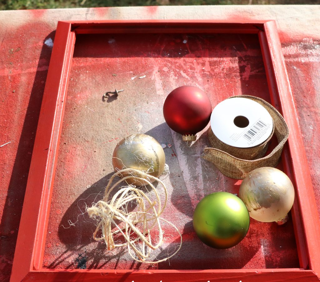 Supplies Needed: Frame, Spray Lacquer, Christmas Ornaments, Jute twine, and thick ribbon.