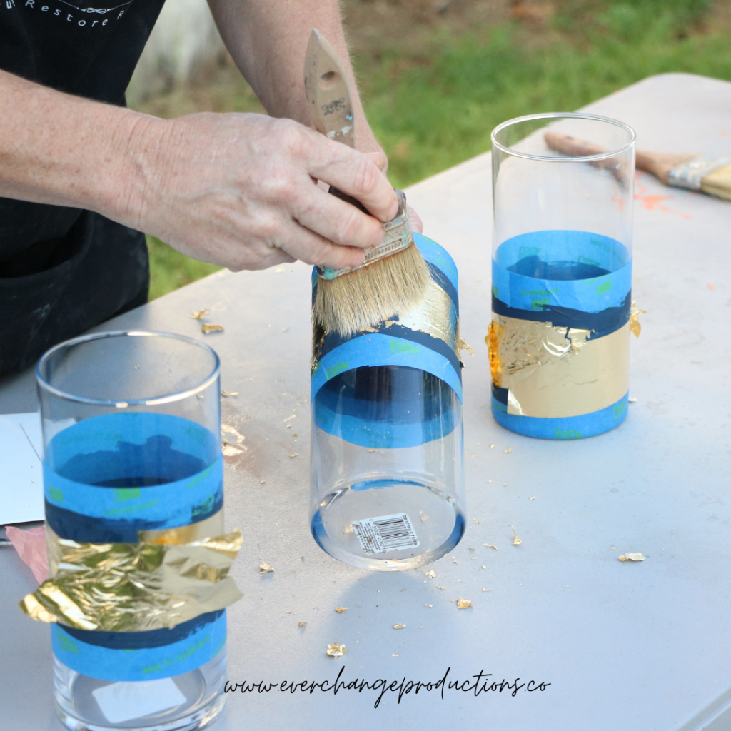 Once the gold leaf is laid out, swiftly move the brush back and forth in a crisscross pattern and remove any extra, unattached gold leaf.